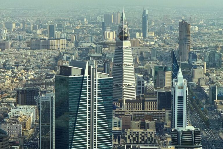 Aerial view of Riyadh's skyline featuring modern skyscrapers on a clear day.