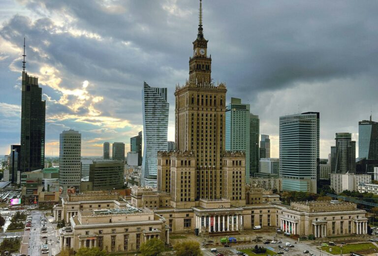 Aerial view of the Palace of Culture and Science surrounded by modern skyscrapers in Warsaw.
