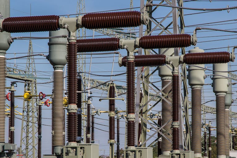 Detailed view of high voltage electrical substation with transformers and power lines.