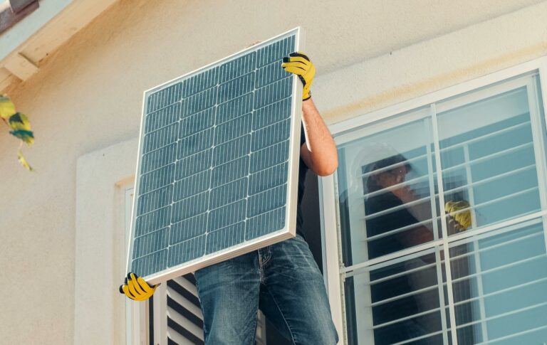 Technician carrying a solar panel on a rooftop for installation, promoting renewable energy.