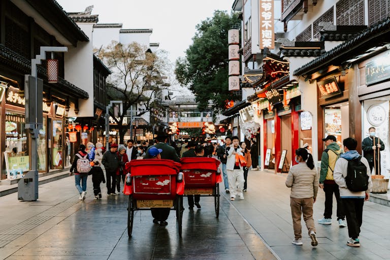 Vibrant street in Nanjing, China, showcasing daily life with people and traditional architecture.