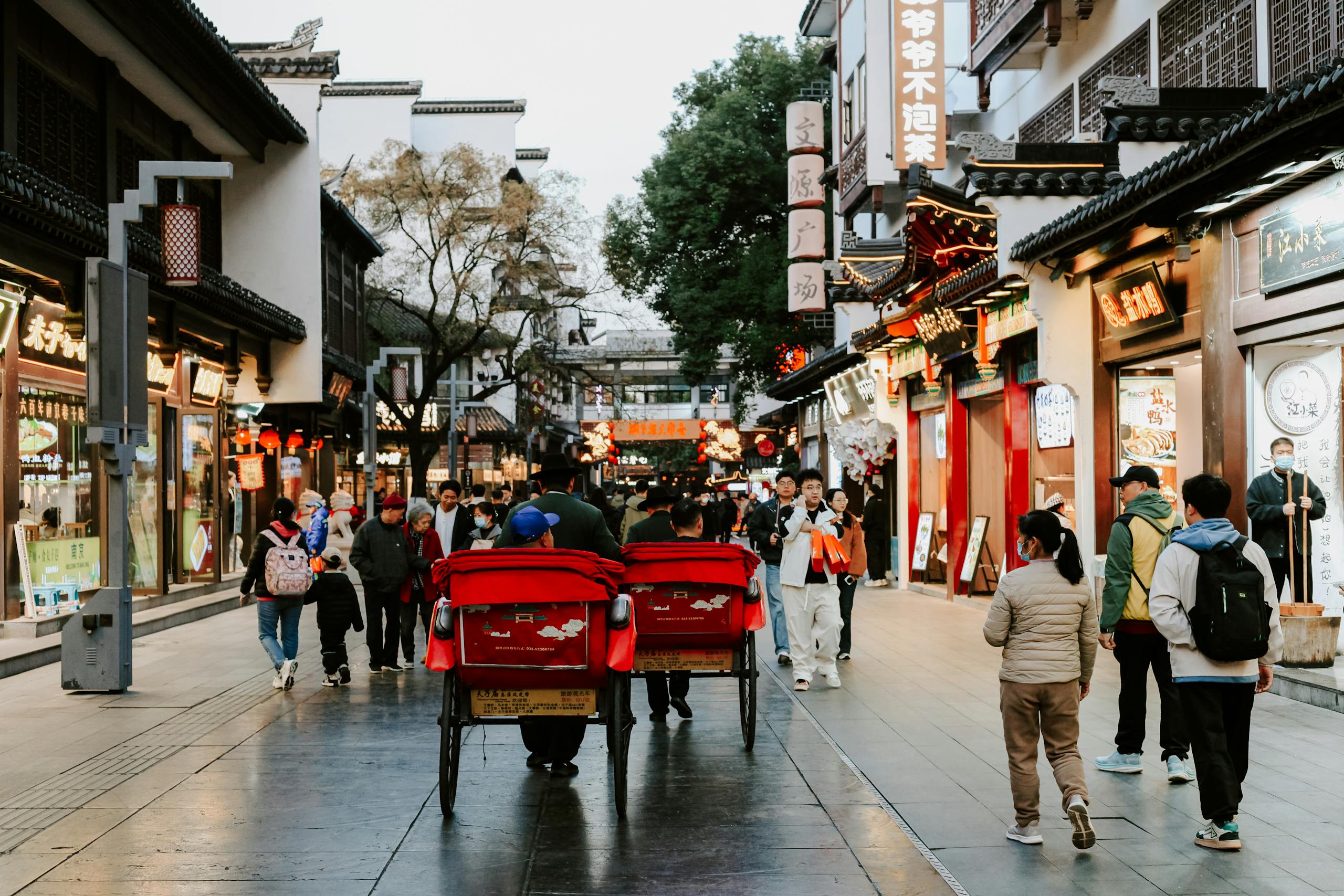 Vibrant street in Nanjing, China, showcasing daily life with people and traditional architecture.